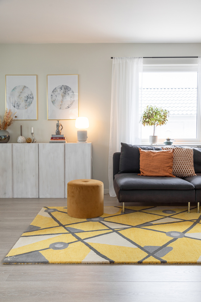 Den gula geometriska mattan från Inhousegroup lyfter vardagsrummet och dess gula toner.