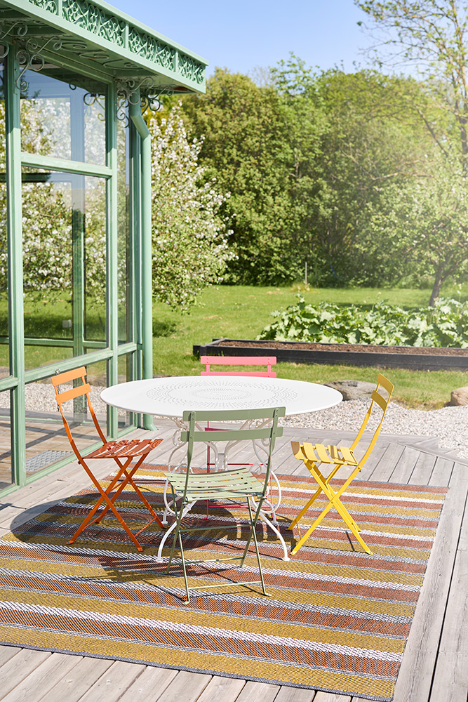 En färgglad ute matta under en cafégrupp en sommardag.